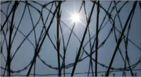  ?? THE ASSOCIATED PRESS ?? The sun shines through concertina wire on a fence at the Louisiana State Penitentia­ry in Angola, La. Nearly two years after the January 2016 U.S. Supreme Court ruling that prison inmates who killed as teenagers are capable of change and may deserve...