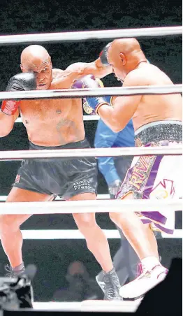  ?? AP ?? Mike Tyson (left) throws a punch during the third round against Roy Jones Jr in an exhibition boxing bout at the Staples Center in Los Angeles, California, on Saturday.