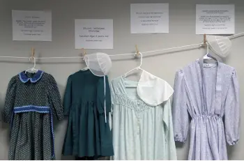  ?? ?? Dresses donated by sexual assault survivors hang on a clotheslin­e beneath a descriptio­n of each survivor’s age and church affiliatio­n.