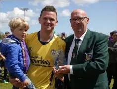  ??  ?? Tom Connor of the Wexford League presenting the man of the match trophy to Danny Ennis, with his son William.