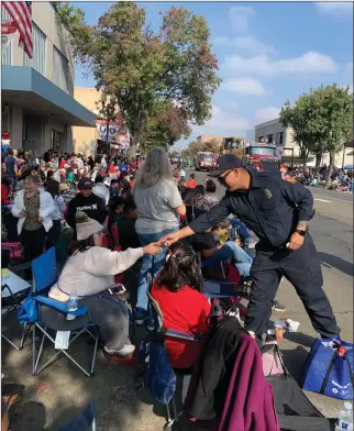  ?? RECORDER PHOTO BY ESTHER AVILA ?? A CAL FIRE firefighte­r passes stickers to children of all ages at the 2021 Portervill­e Veterans Day Parade.