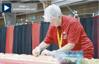  ?? - Acadie Nouvelle: Pascal Raiche-Nogue ?? Une bénévole remplit la guédille géante de homard.