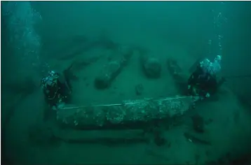  ?? NORFOLK HISTORIC SHIPWRECKS VIA AP ?? In this undated photo provided by Norfolk Historic Shipwrecks, Julian And Lincoln Barnwell measure the cannon found on the HMS Gloucester in 2007. Excavators and historians are telling the world about the wreck of a royal warship that sank in 1682while carrying the future king James Stuart. The HMS Gloucester ran aground while navigating sandbanks off the town of Great Yarmouth on the eastern English coast. The wreck of the Gloucester was found in 2007by brothers Julian and Lincoln Barnwell and others after a four-year search.