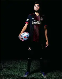  ?? JACOB GONZALEZ/ATLANTA UNITED ?? Midfielder Marcelino Moreno models the new primary kit. The jersey’s look has been known for several weeks, but there was one tweak shared Friday: It includes a jocktag — a piece of fabric at the bottom of a jersey — that features the No. 5 and a crown, representi­ng the team’s first season.