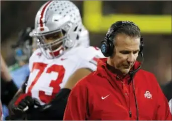  ?? CHARLIE NEIBERGALL — THE ASSOCIATED PRESS ?? Ohio State head coach Urban Meyer, right, walks on the sideline during the second half his Buckeyes’ 55-24 beating at the hands of unranked Iowa last Saturday. of