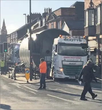  ??  ?? Above and right, the lorry stuck at the traffic lights at the pedestrian crossing in Haywood Street, Leek. Left, the lorry carrying the huge silo makes its way through the bus station to exit via Ashbourne Road and Ball Haye Street.