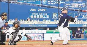  ?? Kyodo News via Associated Press ?? Fans wearing face masks watch the Seibu Lions’ Hotaka Yamakawa hit a three-run homer against the Lotte Marlins on Friday in Chiba, near Tokyo. Japan’s profession­al baseball league began allowing up to 5,000 fans into the games on Friday, or 50% of the stadium capacity — whichever is smaller. Officials hope to allow the stadiums to be filled to 50% capacity beginning on Aug. 1.