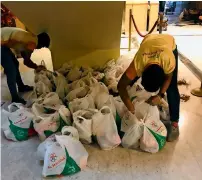  ??  ?? HELPING HAND: Packs of essential supplies are put together for families whose breadwinne­rs are in quarantine facilities.