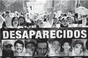  ?? EDUARDO VERDUGO/AP ?? Women carry a banner calling attention to the cases of people who have gone missing in the fight against drug cartels and organized crime, demanding authoritie­s find their loved ones, as they mark Mother’s Day in 2018 in Mexico City.