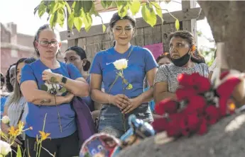  ?? ASHLEE REZIN/SUN-TIMES ?? Mourners gather for a vigil at the Children’s Garden of Hope on Wednesday for the brothers who died in a fire in their nearby basement apartment in West Humboldt Park.