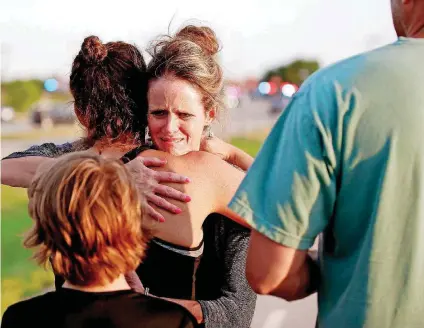  ?? [PHOTO BY BRYAN TERRY, THE OKLAHOMAN] ?? Jennifer Stong hugs Tasha Hunt outside the scene of a shooting on the east side of Lake Hefner in Oklahoma City. Stong was inside the restaurant when the shooting occurred along with Hunt’s children.