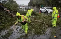  ?? KARL MONDON — BAY AREA NEWS GROUP ?? San Mateo County employees clear a fallen tree Tuesday in Menlo Park, blocking two lanes of traffic on Santa Cruz Avenue.