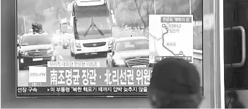  ??  ?? A man watches a television screen broadcasti­ng live footage of vehicles carrying South Korean delegation to attend an inter-Korea talks making its way towards the border truce village of Panmunjom. — AFP photo