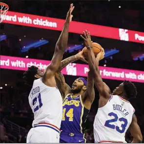  ?? AP/CHRIS SZAGOLA ?? Brandon Ingram (center) of the Los Angeles Lakers goes up for a shot against Joel Embiid (left) and Jimmy Butler of the Philadelph­ia 76ers during the first half Sunday in Philadelph­ia. The 76ers won 143-120.