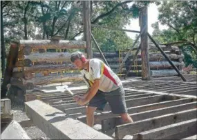  ?? PETE BANNAN – DIGITAL FIRST MEDIA ?? Scott Walker of Axe Handle Timber notches a log as he works on the Jones Log Barn reconstruc­tion at the Duportail House in Chesterbro­ok.