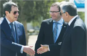  ?? (Yiannis Kourtoglou/Reuters) ?? GREEK CYPRIOT LEADER and Cyprus President Nicos Anastasiad­es (left) shakes hands with Turkish Cypriot leader Mustafa Akinci as UN envoy Espen Barth Eide looks on in the buffer zone of Nicosia Airport yesterday.