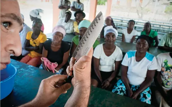  ??  ?? During a 2014 visit to a culinary school in Haiti, Andrés demonstrat­es techniques for cutting vegetables. His World Central Kitchen nonprofit has built or renovated more than 40 school kitchens in the country, which feed 15,000 students daily.