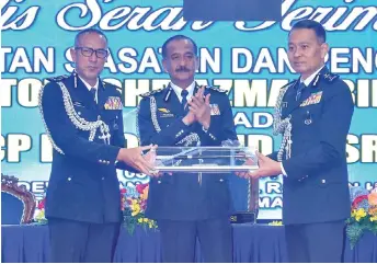  ?? Photo — Bernama ?? Razarudin (centre) witnesses the symbolic handover of duties from Mohd Azman (left) to Mohd Nasri.