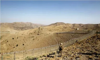  ?? Photograph: Caren Firouz/Reuters ?? A Pakistani soldier stands guard along the border fence with Afghanista­n in North Waziristan. Militants have in recent months stepped up their activities in the region.