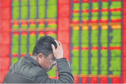  ?? AFP ?? A stock investor gestures as he checks share prices at a securities firm in Fuyang, Anhui province, China.