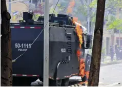  ??  ?? Una tanqueta del Esmad es incendiada por una bomba molotov que arrojó un encapuchad­o.