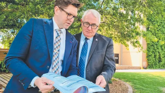  ?? ?? DELIVERED: Toowoomba Deputy Mayor Geoff McDonald (left) and Mayor Paul Antonio look over the council's 2020-21 annual report outside City Hall.