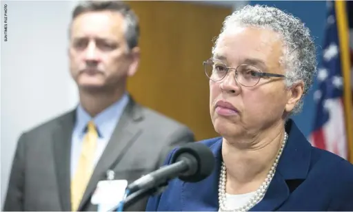  ??  ?? Dr. John Jay Shannon, then-CEO of the Cook County Health System, looks on as Cook County Board President Toni Preckwinkl­e speaks with reporters in 2018.