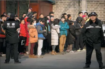  ?? MARK SCHIEFELBE­IN — THE ASSOCIATED PRESS FILE ?? Chinese policemen watch as depositors from Ezubao gather outside the State Bureau for Letters and Calls Reception Division office in Beijing. China’s policy ministry says it investigat­ed 380 online lenders and froze $1.5 billion in assets in a crackdown following an avalanche of scandals in the huge but lightly regulated industry. The ministry said Monday it launched the investigat­ion in June because the industry was increasing­ly risky and rife with complaints about fraud, mismanagem­ent and waste.