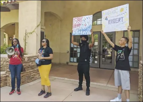  ?? JULIE DRAKE/VALLEY PRESS ?? Debra Lemle (left) talks to the crowd Friday at a protest over the death of her cousin Robert Fuller (below), who was found Wednesday hanging from a tree in Ponciltán Square, as Fuller cousin Pernisha Theus, Kenny Johnson and Noah Yozgadlian look on Many in the crowd disagreed with the county coroner’s ruling that the death was a suicide.