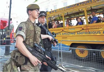  ?? FACUNDO ARRIZABALA­GA, EUROPEAN PRESSPHOTO AGENCY ?? British soldiers and police stand guard near the Houses of Parliament in London on Thursday.