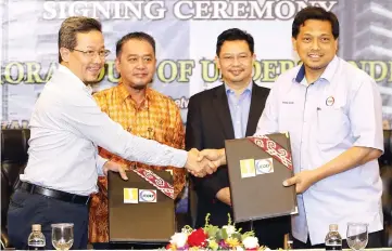  ??  ?? Abdul Hadi (left) exchanges the MoU documents with Mohd Sahir, witnessed by Abdul Aziz (second left) and Kamaruzzam­an.