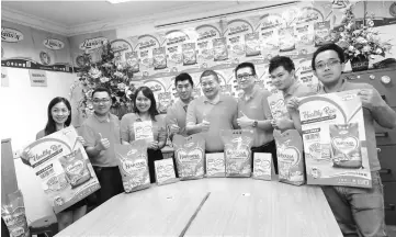  ??  ?? Lim (fourth right) and Liansin staff promote the calendar giveaway with Haryana rice.