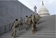  ?? AP Photo/patrick Semansky, File ?? ■ National Guard members take a staircase toward the U.S. Capitol building Jan. 18 before a rehearsal for President-elect Joe Biden’s presidenti­al inaugurati­on in Washington. Soldiers are leaving the Army National Guard at a faster rate than they are enlisting, fueling concerns that in the coming years units around the country may not meet military requiremen­ts for overseas and other deployment­s. Officials say the number of soldiers retiring or leaving the Guard each month in the past year has exceeded those coming in, for a total annual loss of about 7,500 service members.