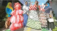  ?? PUGUH SUJIATMIKO/JAWA POS ?? KREATIF: Camat Kenjeran Henni Indriaty (dua dari kiri) memamerkan gaun dari daur ulang plastik di Sidotopo Wetan.