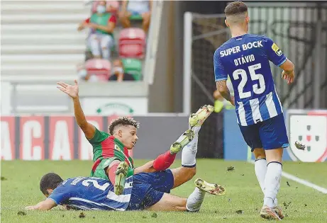  ??  ?? Bruno Costa e André Vidigal caídos na relva, com Otávio a ver: relvado do Marítimo foi criticado pelos portistas