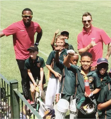  ??  ?? THUMBS UP FOR THE CAMERA: Kagiso Rabada and Dale Steyn with learners from Doringkloo­f Primary School in Pretoria yesterday.