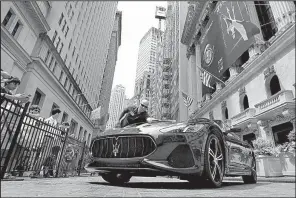  ?? AP/RICHARD DREW ?? A worker from Fiat Chrysler Automobile­s cleans a Maserati GranTurism­o MC displayed Tuesday in front of the New York Stock Exchange.