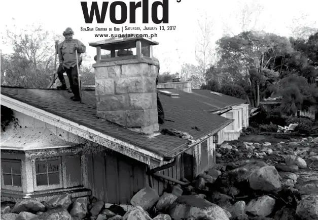  ??  ?? A firefighte­r stands on the roof of a house submerged in mud and rocks Wednesday, Jan. 10, 2018, in Montecito, Calif. (AP)