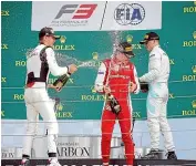  ??  ?? Marcus Armstrong, centre, gets showered in champagne as he celebrates his victory in Hungary.
