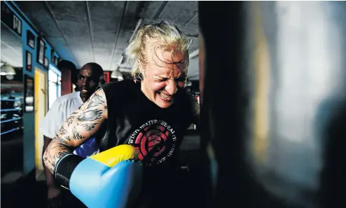  ?? Picture: Moeletsi Mabe ?? Hedda Wolmarans, a promising 29-year-old junior-welterweig­ht, attacks the bag with her trainer Vusi Mtolo in the background.