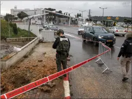  ?? JALAA MAREY – GETTY IMAGES ?? An Israeli police officer inspects the impact crater left by a rocket fired from southern Lebanon where it landed near the entrance of a hospital in Safed on Wednesday.