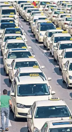  ?? FOTO: LINO MIRGELER/DPA ?? Hunderte Taxen stehen während einer Demonstrat­ion gegen die „Uberisieru­ng“im September vor dem Münchner Siegestor.