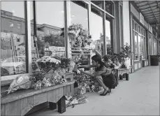  ?? WILLIAM WIDMER/THE NEW YORK TIMES ?? A woman places items at a makeshift memorial Friday outside Red Arrow Workshop, a boutique owned by Jillian Johnson, one of the victims of the previous night’s fatal shootings at a nearby theater in Lafayette, La. John R. Houser, who killed two and...