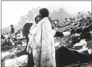  ?? AP ?? This now iconic image of Nick Ercoline and Bobbi Kelly embracing at the Woodstock Music and Art Festival in 1969 had been dating for just 10 weeks when freelance photograph­er Burk Uzzle took this photo. They now have been married for 47 years.