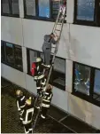  ??  ?? Ein Mitarbeite­r wird mithilfe einer Leiter aus einem Gebäude gerettet.