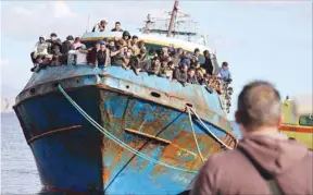  ?? ?? Migrants stand onboard a fishing boat at the port of Paleochora, following a rescue operation off the island of Crete, Greece yesterday. (Reuters)