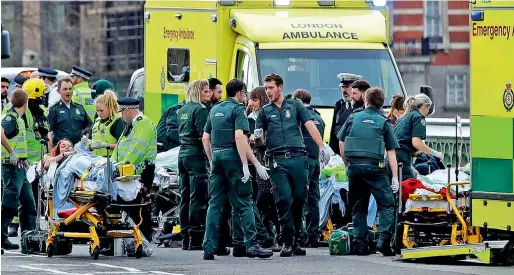  ?? AP ?? Emergency services staff provide medical attention close to the Houses of Parliament in London on Wednesday. —