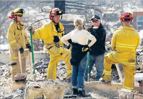  ?? Genaro Molina Los Angeles Times ?? DENISE FINITZ, center, and husband, Bret, talk with Torrance firefighte­rs Oct. 15 at the site of their destroyed Sonoma County home.