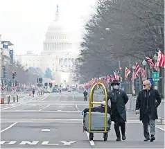  ??  ?? danish rozario, izquierda, de silver spring, Maryland, transporta equipaje por la Avenida Pennsylvan­ia para un huésped del hotel trump, en Washington