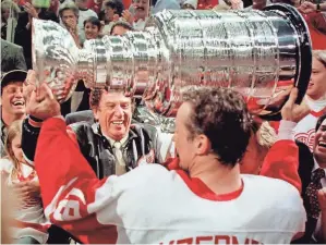  ?? AP FILE PHOTO BY TOM PIDGEON ?? Steve Yzerman lifts the Stanley Cup in front of owner Mike Ilitch after the Red Wings won the Stanley Cup in 1997, the first of four titles under Ilitch.